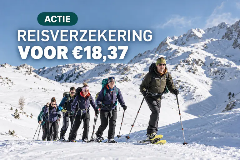 Een groep wandelaars op een besneeuwd bergpad met de tekst: Actie: Reisverzekering voor € 18,37.
